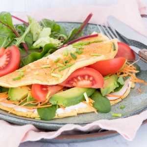Omelet bakken met roomkaas, kip en groenten