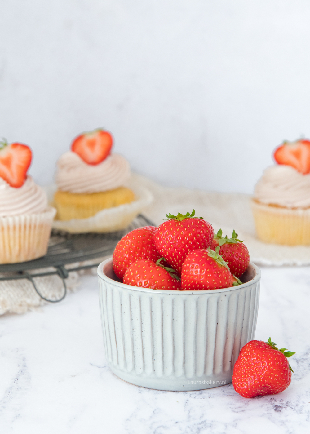 Aardbeien met aardbei cupcakes op achtergrond