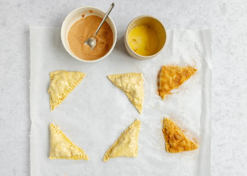 Mini appelflapjes met ei afsmeren en met kaneelsuiker bestrooien