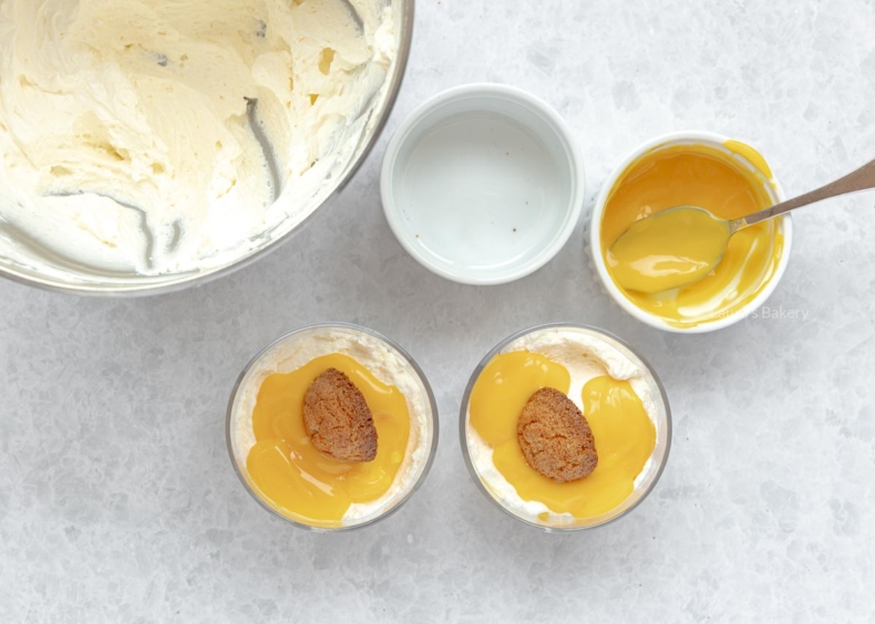 Top opnieuw af met een laag mascarponeroom, daarna advocaat en tot slot een bitterkoekje