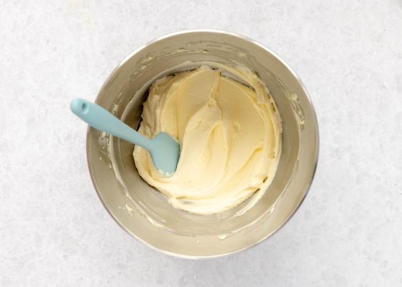 Maak de frosting door de boter romig te kloppen en hier roomkaas, vanille-extract en poedersuiker door te mengen.