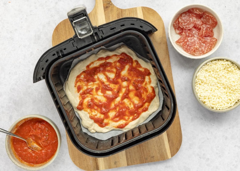 Plaats de pizza in de voorverwarmde airfryer en bak 8 minuten.