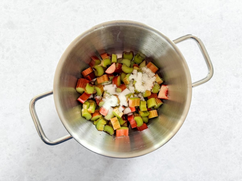 rabarber en suiker in pan voor rabarber-aardbei compote